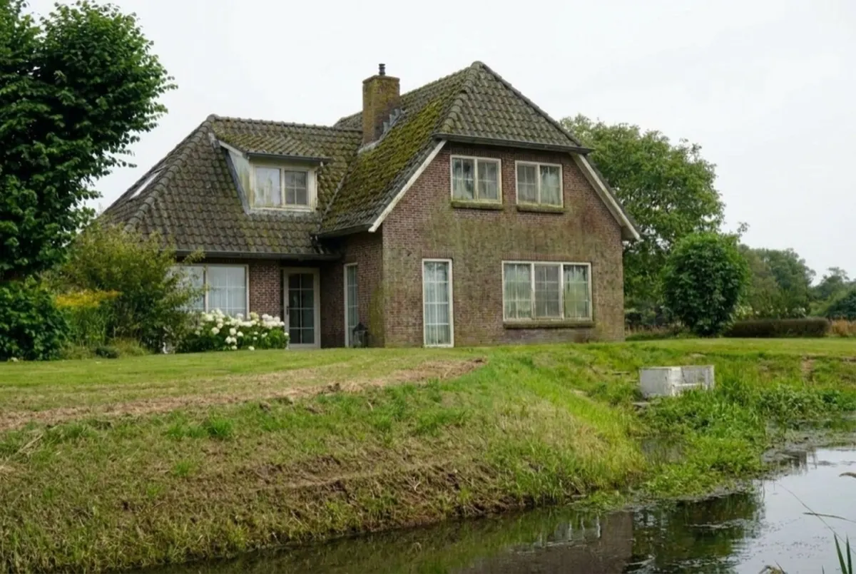 Woning vóór de reiniging: mos op het dak en aanslag op de gevel